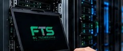 Engineer using a laptop connected to a server rack